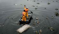 Cleaning staffers collect a bed mattress at the mouth of the Meriti river in Duque de Caxias next to Rio de Janeiro, July 20, 2016. AFP