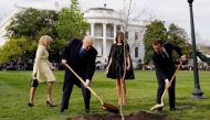 Donald Trump and Emmanuel Macron shovel dirt onto a freshly planted oak tree as first lady Melania Trump and Brigitte Macron watch on the South Lawn of the White House, April 23, 2018. Reuters /  Joshua Roberts