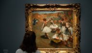 A person looks at the painting Dancers on stage made around 1889 and 1894 by Edgar Degas, during the exhibition Degas at the Opera at the Museum of Orsay, Paris, on September 20, 2019. AFP / Francois Guillot