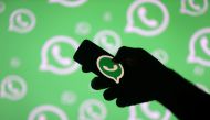 A man poses with a smartphone in front of displayed Whatsapp logo in this illustration dated September 14, 2017. Reuters / Dado Ruvic