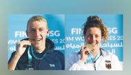 Marc-Antoine Olivier (left) and Leonie Beck bite their gold medals after recording wins at Katara Beach yesterday.