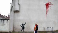 A piece of street art showing the stencilled image of a young girl firing a slingshot of flowers and leaves and confirmed, on his official social media accounts, by elusive artist Banksy as his work is pictured on the wall of a building in Bristol on Febr
