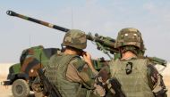 French soldiers stand next to a CAESAR a French self-propelled 155 mm 52-calibre gun-howitzer in the Qayyarah base, south of Mosul on October 31, 2016. AFP