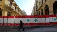 FILE PHOTO: A man walks past concrete barriers erected by authorities to block a street leading to the parliament building in Beirut, Lebanon January 24, 2020. REUTERS/Aziz Taher