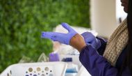 A customer tries on protective gloves in the coronavirus pop-up store by Adilisha Patrom, owner of the Suites DC, a co-working and event space across the street from Gallaudet University, who started her pop-up store that sells face masks, protective glov