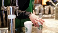 A barista serves beverages in single use cups inside a Starbucks in London, Britain, March 6, 2020. REUTERS/Henry Nicholls