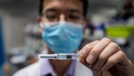 In this picture taken on April 29, 2020, an engineer shows an experimental vaccine for the COVID-19 coronavirus. AFP / NICOLAS ASFOURI 