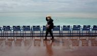 A woman wears a face mak as she walks down the Promenade des anglais avenue in Nice, French Riviera, on May 11, 2020, on the first day of the lift of lockdown measures set up on March 17 in France to curb the spread of the COVID-19 caused by the novel cor