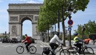 In this file photo taken on May 11, 2020 People ride on their bicycles in The Champs Elysees Avenue , in Paris, on May 11, 2020, on the first day of France's easing of lockdown measures in place for 55 days to curb the spread of the COVID-19 pandemic, cau