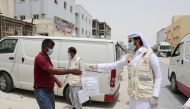 QFC and Qatar Charity officials giving away protective kits to Industrial Area workers 
