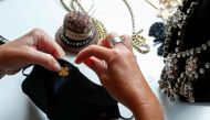 Belgian jewellery designer Olivia Hainaut sews a gold-plated clover on a protective mask in her workshop amid the coronavirus disease (COVID-19) outbreak in Brussels, Belgium July 22, 2020. Picture taken July 22, 2020. REUTERS/Francois Lenoir