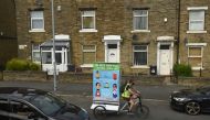 In a promotion funded by Calderdale Council, Phil Mearns rides his ad bike displaying advice on how to slow the spread of the coronavirus through the streets of Halifax in northern England on August 9, 2020, as local lockdown restrictions are reimposed du