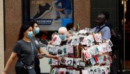 Women walk by a man selling face masks in Manchester city centre, following the outbreak of the coronavirus disease (COVID-19), Manchester, Britain, August 10, 2020. REUTERS/Jason Cairnduff
