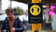 A man walks by a social distancing sign on the first day of New Zealand's new coronavirus disease (COVID-19) safety measure that mandates wearing of a mask on public transport, in Auckland, New Zealand, August 31, 2020. REUTERS/Fiona Goodall
