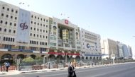 This file photo shows a man walking across the Grand Hamad Street, also known as the ‘Bank Street’ in Doha, Qatar. 
