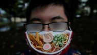 Japanese designer Takahiro Shibata's glasses fog up as he wears a protective mask that looks like a steaming bowl of ramen noodle soup while posing for a photo at a park, following the coronavirus disease (COVID-19) outbreak in Yokohama, Japan September 2