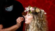 French model Tiffany Fournier has her make-up applied before posing for a digital presentation as part of the spring/summer 2021 collections for the Polish fashion house La Metamorphose, in Paris, France, September 26, 2020. Reuters/Charles Platiau