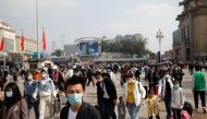 People wearing masks following the coronavirus disease (COVID-19) outbreak are seen with luggage outside Beijing Railway Station, during the holidays of Mid-Autumn Festival and National Day, in China October 1, 2020. REUTERS/Carlos Garcia Rawlins