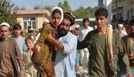 An injured youth (C-L) is carried to a hospital following a car bomb attack that targeted a government building, in the Ghani Khel district of Nangarhar province, about 35 km from Jalalabad on October 3, 2020.  AFP / NOORULLAH SHIRZADA
