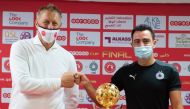 Al Sadd coach Xavi Hernandez (right) and Al Arabi coach Heimir Hallgrímsson pose with the Ooredoo Cup trophy during a press conference in Doha, yesterday. 