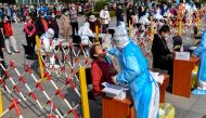A health worker takes a swab from a resident to be tested for the COVID-19 coronavirus in Qingdao, in China's eastern Shandong province on October 12, 2020. China OUT / AFP / STR