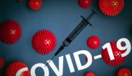 This photograph taken on October 7, 2020 shows a syringe on an illustration representing Covid-19 (novel coronavirus), in Toulouse, southwestern France. / AFP / Lionel BONAVENTURE
