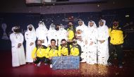 Qatar SC players and officials pose with the Amir Cup Table Tennis Championship trophy after winning the final against Al Sadd, yesterday.   