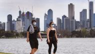 People walk around Melbourne's Albert Park Lake on October 12, 2020, as they use their two hours daily exercise allowed during the stage four restrictions due to the COVID-19 coronavirus outbreak. / AFP / William WEST
