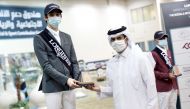 Khalifa Abdulla Al Khaldi receiving the Small Tour winner's trophy on the opening day of the second round of the Fourth Longines Hathab Equestrian Series at Qatar Equestrian Federation’s Indoor Arena yesterday