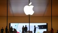 In this file photo taken on October 19, 2020 people walk inside an Apple store in Beijing. A steep drop in iPhone sales in the latest quarter cut Apple's profit by 7 percent to $12.7 billion, the company announced October 29, 2020, sending the company's s
