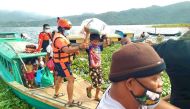 A handout photo taken on October 31, 2020 from the Facebook page of Philippine Coast Guard, shows personnels from the coast guard evacuating residents from the coastal villages of Buhi town, Camarines Sur province, south of Manila, to a safer place, ahead