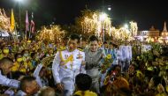Thailand's King Maha Vajiralongkorn and Queen Suthida greet royalist supporters outside the Grand Palace in Bangkok on November 1, 2020 after presiding over a religious ceremony at a Buddhist temple inside the palace. / AFP / Jack TAYLOR