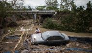 A man sits beside a car, washed away by floods caused by Typhoon Goni, in Barangay San Isidro, Batangas City, Philippines, November 2, 2020. REUTERS/Eloisa Lopez