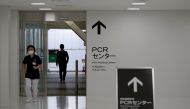 A medical worker walks at the entrance of the newly-opened Narita International Airport PCR Center operated by Nippon Medical School Foundation, a coronavirus disease (COVID-19) testing facility aimed at outbound travelers who need proof that they do not 