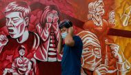 A man fixes his mask for protection against the coronavirus disease (COVID-19) as he walks past a mural dedicated to healthcare workers, in Pasig City, Metro Manila, Philippines, October 30, 2020. REUTERS/Eloisa Lopez