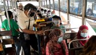 Passengers on board a bus wear face masks and face shields, both mandatory in public transportation, to help curb coronavirus disease (COVID-19) infections, in Quezon City, Metro Manila, Philippines, August 19, 2020. REUTERS/Eloisa Lopez/File Photo