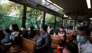 Visitors wearing face masks following the coronavirus disease (COVID-19) outbreak look at the view from inside the Peak tram in Hong Kong, China November 10, 2020. Picture taken November 10, 2020. REUTERS/Lam Yik