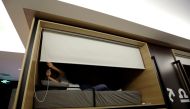 Zhang Shuangjie, an IT engineer at BaishanCloud, drops the curtain as he prepares to sleep around midnight in an individual sleeping quarter, in the office, in Beijing, China, April 26, 2016. REUTERS/Jason Lee/File Photo