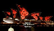 The sails of the Sydney Opera House are illuminated by a projection of poppies to mark World War I Remembrance Day in Sydney on November 11, 2020. / AFP / Saeed KHAN