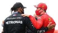 Mercedes' Lewis Hamilton is congratulated by Ferrari's Sebastian Vettel after winning the race and the world championship REUTERS/Clive Mason