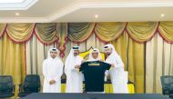 Qatar SC officials holding a team jersey with Ahmed Khalil Al Mohannadi during the ceremony.