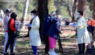 Medical staff members take details from people queuing at a coronavirus disease (COVID-19) testing site as the state of South Australia experiences an outbreak, in Adelaide, Australia, November 17, 2020. AAP Image/Kelly Barnes via REUTERS