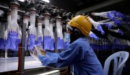 A worker inspects newly-made gloves at Top Glove factory in Shah Alam, Malaysia August 26, 2020. REUTERS/Lim Huey Teng/File Photo