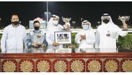 Jockey Soufiane Saadi is seen with his team after he won the Muraikh Cup with X Force in race meeting 11 of the new horse racing season at Qatar Racing and Equestrian Club. 