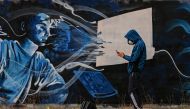 Street artist SF paints a mural on a wall, inspired by the 2nd lockdown in Greece due to the covid_19 pandemic in Athens on November 25, 2020. / AFP / ARIS MESSINIS
