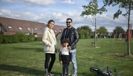 In this photograph taken on September 24, 2020, 32 year-old Ahmad (R) with his wife Alia and their five year old son Adam pose standing in a park in the town of Duiven, The Netherlands. (AFP / ARIS MESSINIS)