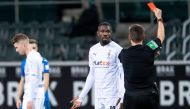 Borussia Moenchengladbach's Marcus Thuram is shown a red card by the referee Pool via REUTERS/Marius Becker