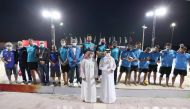 Qatar Olympic Committee (QOC) Secretary-General Jassim Rashid Al Buenain posing for a photograph with the beach volleyball players and officials during the opening ceremony of the inaugural QOC Beach Games at Aspire Park, yesterday. 