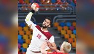 Qatar’s Frankis Marzo in action with Denmark’s Magnus Saugstrup Jensen during their Group 2 match in Cairo, yesterday.  