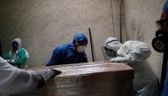 FILE PHOTO: Funeral and crematorium employees work on a coffin carrying the body of a person who died from the coronavirus disease (COVID-19) before its cremation, as the number of deaths continues to rise due to the coronavirus disease (COVID-19) outbrea